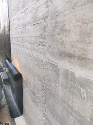 Stesa della guaina bituminosa su muro in cemento armato. Segiar