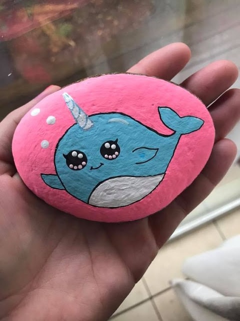 Narwhal painted rock with pink background  Artist credit: Emily Gilmore of EmzRockz