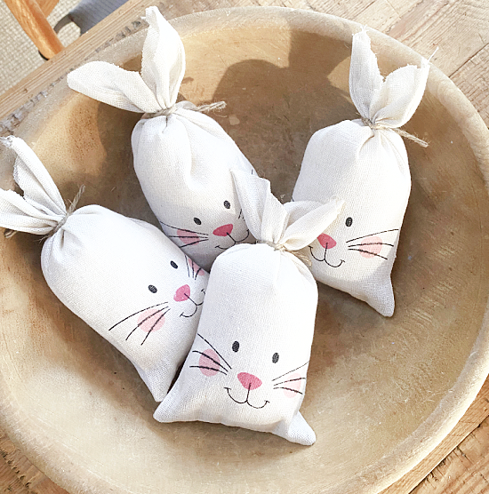 wooden bowl with 4 stuffed bunnies