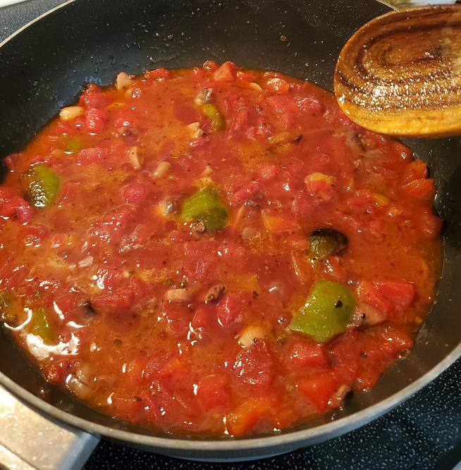 this is a pan of tomato sauce with meat and peppers
