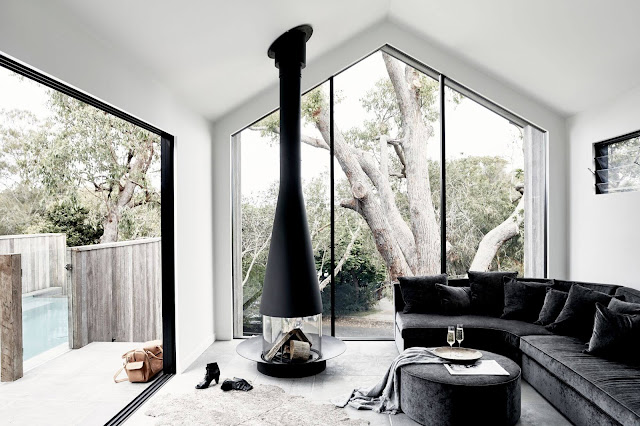 The Cabin from Byron Beach Abodes with large glass windows and black free standing fireplace