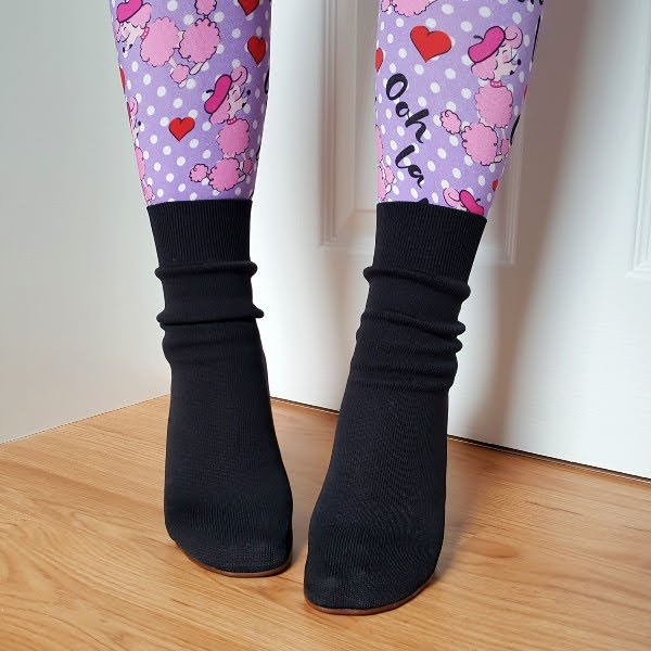 wearing black knit sock boots with purple and pink poodle print tights