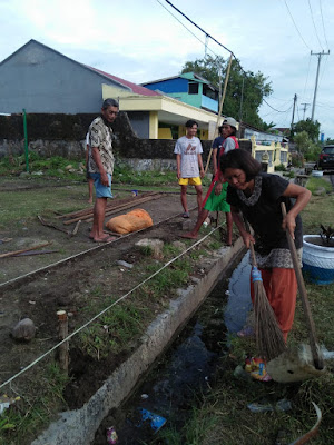 warga membersihkan selokan