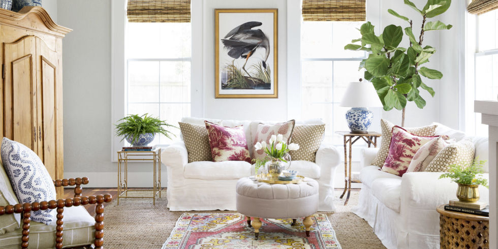 Living Room Charming cottage style living room with white sofas, bamboo blinds, soft red accents, and interior design by Holly Mathis. #cottagestyle #livingroom #modernfarmhouse #hollymathis