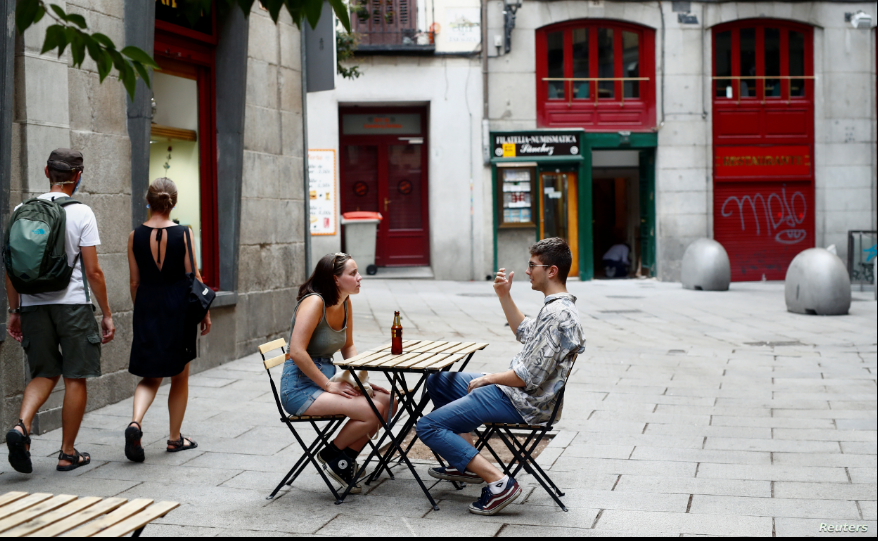 Una pareja conversa en la sección exterior de un bar en Madrid, España, el 28 de julio de 2020 / REUTERS