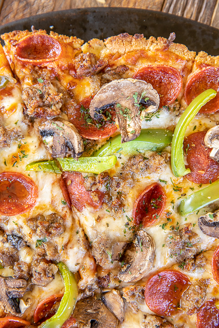 Keto Pizza Crust - a delicious low-carb friendly pizza crust! SO easy to make and tastes great! Almond flour, parmesan cheese, oregano, salt, coconut oil, and an egg. Only takes a minute to make. Top with a sugar-free pizza sauce, mozzarella, and your favorite pizza toppings. Tastes like you are cheating, but you aren't! #pizza #keto #lowcarb #glutenfree slice of pizza