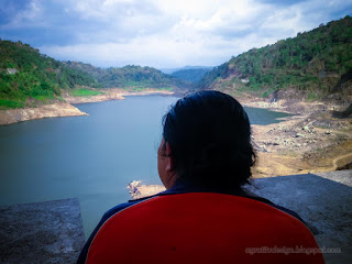 Woman Traveler Enjoy A Beautiful Natural Scenery Of The Large Titab Ularan Dam In The Sunny Cloudy Day Of Dry Season North Bali Indonesia