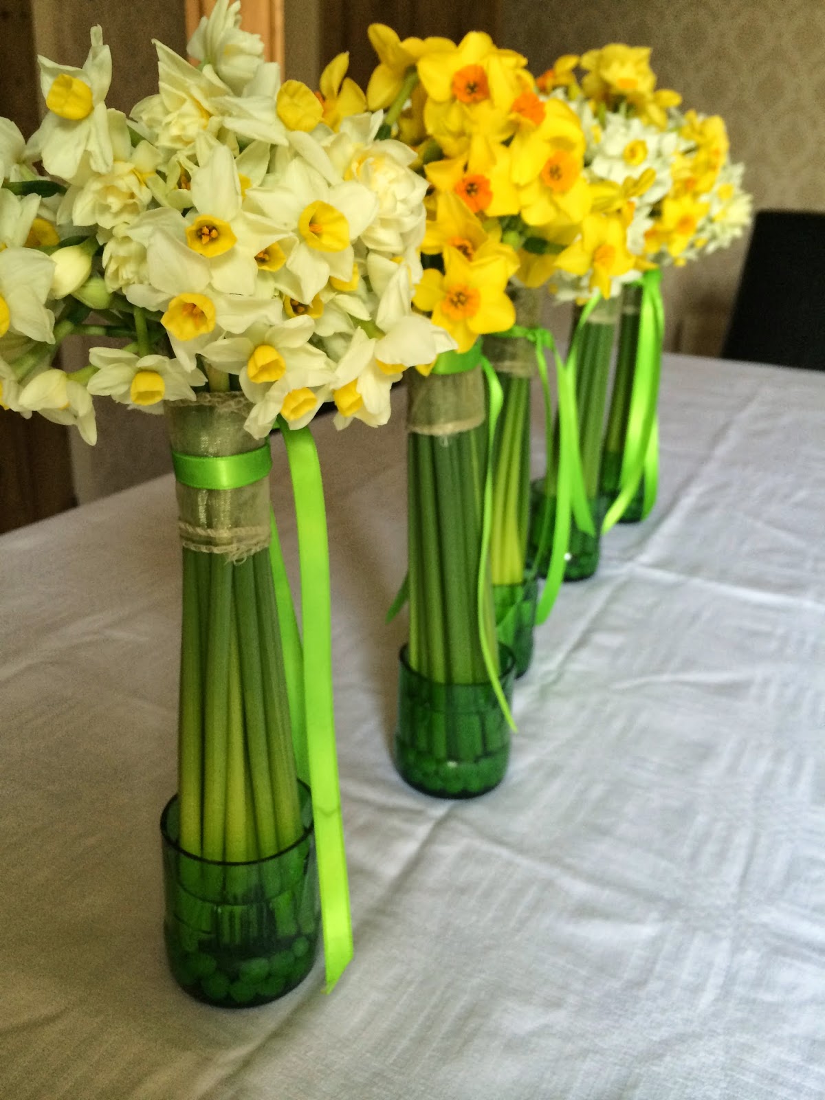 Gorgeous scented British narcissi in recycled bottle vases