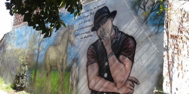 Imagen mural del músico MC Piri del género musical Hip Hop. Se observa una porción de una de sus canciones que dice: CAMBIANDOME A MI MISMO ES COMO TRAIGO PAZ A MI TIERRA PORQUE ES EN EL CORAZON DONDE COMIENZAN LAS GUERRAS.