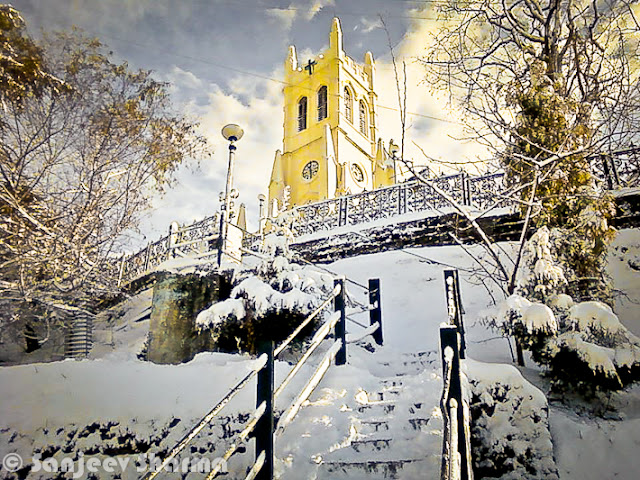 Shimla has been getting snowfall since 5th January 2012 and Sajeev has been capturing each moment of post-snowfall moments at various places around Shimla - Mall Road, Ridge ground, Scandal point, Lakkar Bazar etc. This year Shimla is getting heavy snowfall and some of the evidences can be seen in this Photo Journey from last week... Sanjeev Sharma with unknown Cameraman, Zee news, Shimla :)Sanjeev himself on Ridge Ground, while it's snowing on Ridge Ground, Shimla, Himachal Pradesh, India. You can see Christ Church on one corner of the Ridge and Shimla Library adjacent to it. Somehow Shimla is known by these two buildings. Yesterday only I saw fridge magnet at Connaught Place, Delhi with these two buildings carved on a marble piece to make a souvenir of Shimla, Himachal Pradesh. There were lot of other stuff form various cities of India like Jaipur, Varanasi, Maisoore etc.Here is a photograph with footmarks of people who were enjoying fresh snowfall on Ridge Ground and left for their homes.Although there are still few folks roaming around. Whole sky is covered with dense mist or clouds. The leading path is actually touching Mall Road, which is one of the main places people love to roam around in Shimla. buildings on left side are Goofa Restaurant and Bar by HPTDC and Gaitey Theatre, which was renovated last year only.Here is a closer look to Goofa Restaurant and Bar. One of the decent place to have dinner on Ridge Ground, although our experience of Goofa bar was not so good, when we were in University. But this is considered one of the decent places..Business in Snow... The famous Krishna bakers is closed but 100 Pipers and other brands of whiskey are available. And probably Rum would be more demand in such a lovely snow. Just notice the height of snow on the road... All these shops are located on lower part of the Mall Road...Another view of ridge Ground from an elevated boundary which leads towards Jakhu Temple, Shimla.Snow was on and off during last 10 days and yesterday there was heavy snowfall, which made people comment negatively about it. Till yesterday everyone from Shimla was putting happy and interesting statuses about Snowfall on facebook. But suddenly things changed yesterday when this snow started impacting lives of people in Shimla. For tourists, heavy snowfall can be good but for loacl folks it creates lot of problems at times. Water and Electricity supply is one of the main challenge during heavy snowfall hours. Notice the forest behind Mr. Sanjeev which are still white and these high deodars look amazing with snow on top of themPath created by Ambulance is being smartly used by these folks. vehicles are not allowed on Ridge Ground and Mall Roads.. Only Ambulance or police vehicles are allowed as and when required. Although many bollywood movies have shown vehicles flying on ridge ground. All that is done after special permissions from Shimla Authorities.Here is a a view of Shimla Ice Skating Club, which is located just below Lakkar Bazar, Shimla. This club is also visible from top of Indira Market on Ridge Ground. During December a national level event is organized, where lot of professionals come to this club for showing their Ice Skating performances. Even without ice these folks from Shimla can be seen on Mall Road and Ridge on  every Saturday :)Evening view of Ridge with spoiled snow... Place like Shimla are enjoyable either during fresh snowfall or without any snow. After 2 or 3 days of snowfall, snow melts or take a shape of huge pieces of ice which are risky to walk and dirty as well. During that time, snow in places are Kufri or Narkanda is more enjoyable. In fact, these days Skiing training is going on at Dhomri, Narkanda...Mr. Sanjeev, covered with multi-layered cloths and posing for a photograph against scandal point. Scandal point is a place from where two roads are diverted - one towards Ridge ground and other continues as Mall Road towards Shimla Town Hall and Gaiety Theatre.Gukli just stood up for this photograph, otherwise he must be busy in making snowman or playing snowballs :) ... Smile on his face is telling about the excitement about fresh snowfall in Shimla.Every year tourists come to Shimla during last week of Decemeber in a hope of Snowfall, but now timings have shifted a bit. For last few years, Shimla is getting snowfall in second week of January or towards end of first week.This year (2012), it was first time that some of the regions in Himachal got snowfall. Places like Hamirpur were also covered with white sheet of snow, although it remained only for few hours and then disappeared. At the same time various places of Kangra District got snowfall - Nagrota, Palampur, Dharmshala and Kangra town itself. Kangra Twon got snowfall after 52 years...Sanjeev is still waiting for his car to be uncovered of Snow Blanket... Try to imagine, how people in Shimla must be commuting to their offices and other places for some work... Conditions get worse in case of continuous snowfall for longer period of time.Many businessmen in Shimla make more money during tis season but at the same time, many folks with small setups loose lot of business due to heavy snow. I am sure that every weekend Shimla is getting lot of tourists from Punjab and Delhi...Sanjeev in perfect pose for this photograph with snow in the background :) (Shimla, Himachal Pradesh, India)Another amazing view of Ridge Ground covered with Snow and few folks walking on it... I still remember the day when I saw snowfall first time and we came to Mall Road for playing with snowballs... Everyone from our class was on Mall Road and whole day was full of fun and enjoyment....Sanjeev looks pretty happy and hopeful about this snowfall... Probably he is done with his walk on Mall Road and moving towards Press Club at Indira Market on Ridge ground of Shimla TownHere is last and wonderful photograph of this amazing Photo Journey by Sanjeev Sharma. Hope that snowfall comes with happiness and keep whole environment cheerful without any damage to anyone. And if you are amongst ones who have never seen snowfall, this is right time to plan your trip to Shimla and enjoy it.Thanks a Lot Sanjeev Sharma for such a Lovely Photo Journey with full of life photographs from last one week.