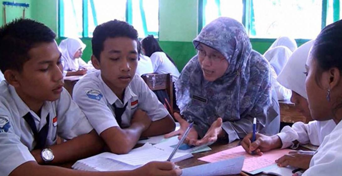 guru muslimah membantu siswa praktikum