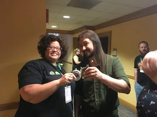 Kayla and Christopher swapping flasks at GeeklyCon 2018