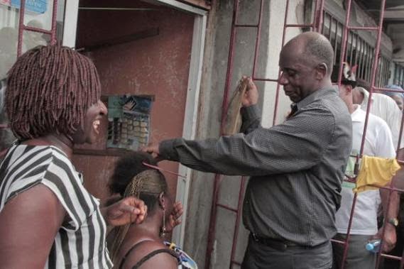 00 Photo: Governor Rotimi Amaechi pictured making a woman's hair