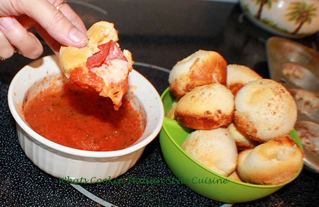 these are homemade pizza dough stuffed with pepperoni, mozzarella cheese and provolone cheese and  placed into a cupcake tin . This stuffed pizza dough after its baked is dipped into a marinara sauce. The photo shows the inside of the pepperoni stuffed pizza with melted cheese oozing out and dipped into the marinara sauce. This recipe shows step by step how to make pepperoni pizza cups