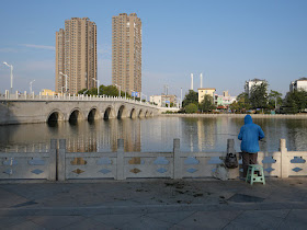 man fishing next to Heping Bridge in Xuzhou