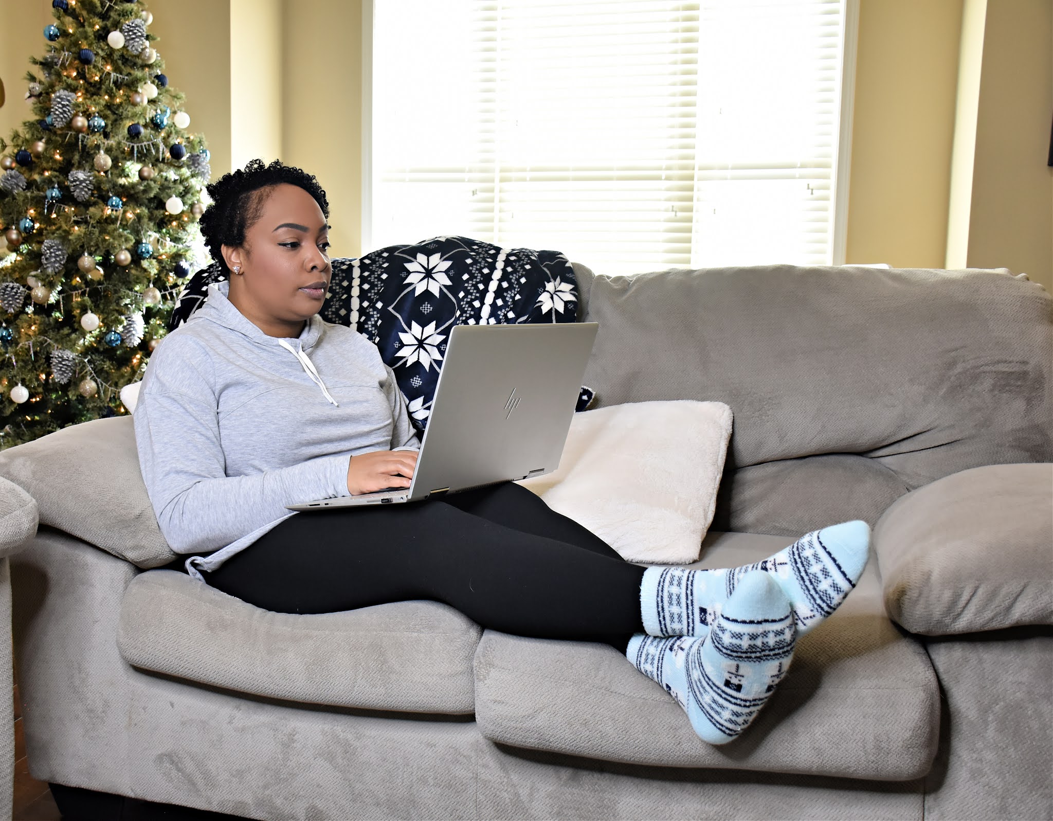 Cozy on a couch online shopping during Christmas