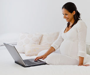pregnant woman on computer doing research