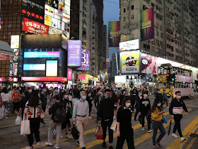 people wearing face masks crossing a road
