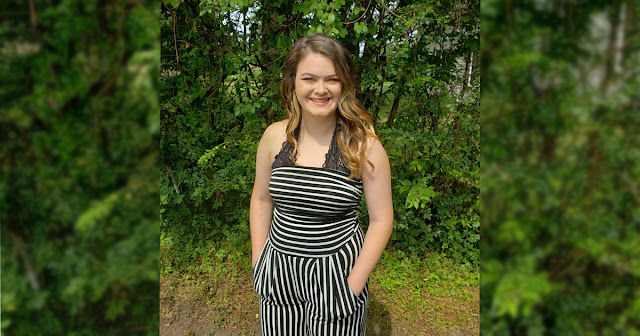 Woman stands in front of plants