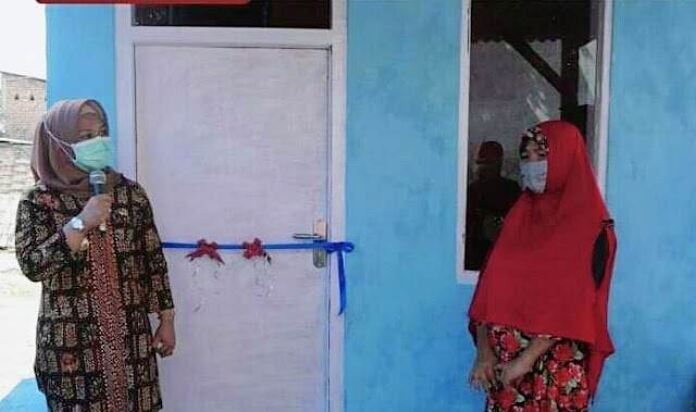 Usai Direnovasi Pemda, Ning Ita Serahkan Kunci Rumah Bu Romlah Mojokerto - Wali Kota Mojokerto Ika Puspitasari atau yang akrab disapa Ning Ita menyerahkan secara simbolis kunci rumah milik warga Lingkungan Balongrawe, Kelurahan Kedundung, Kecamatan Magersari, usai mendapatkan renovasi dari pemerintah daerah, Jumat (19/6/2020). Romlah, pemilik rumah yang ambruk akibat diterjang angin kencang dan hujan deras satu bulan lalu, akhirnya bisa kembali menempati rumahnya usai diperbaiki oleh Pemerintah Kota Mojokerto. Penyerahan kunci secara simbolis ini, dilakukan langsung oleh Wali Kota Ning Ita, usai menggelar acara paripurna peringatan Hari Jadi Kota Mojokerto ke-102 secara virtual, dengan disaksikan oleh Pelaksana Tugas (Plt) Kepala Dinas Sosial Kota Mojokerto Heru Setyadi, camat dan lurah. Rumah berukuran 4x6 yang dulunya terbuat dari bambu, telah direnovasi menjadi bangunan dengan material kuat dan kokoh. Wali Kota Ning Ita pun berharap, dengan direnovasinya rumah tersebut, Romlah bersama keluarga bisa mendapatkan kenyamanan selama tinggal disana. Seperti yang diketahui sebelumnya, rumah Romlah (52) warga Lingkungan Balongrawe, Kelurahan Kedundung, Kecamatan Magersari, Kota Mojokerto mendadak ambruk usai diguyur hujan deras dan angin kencang yang berlangsung cukup lama pada Senin (11/5/2020) dini hari. Diduga, rumah semi permanen yang terbuat dari bambu tersebut, telah lapuk dimakan usia. Warga yang mengetahui hal tersebut, kemudian bergotong -royong mengevakuasi pemilik rumah untuk di bawah ke Rumah Aman milik Dinas Sosial Kota Mojokerto.(Jayak)