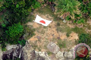 Foto udara Kyodo News menunjukkan bendera Jepang di salah satu pulau di kepulauan Senkaku/Diaoyu yang menjadi sengketa antara Jepang dan China di Laut China Selatan, Rabu (19/9). (Reuters)