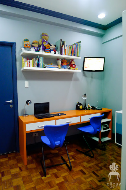 desk study area of a boys room with blue and orange color accent