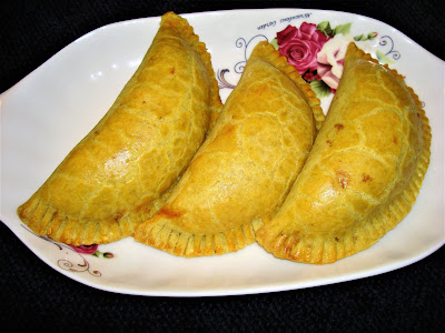 JAMAICAN PORK PATTIES PORTIONS: 10 INGREDIENTS FOR THE PATTIES CRUST 4 cups all-purpose flour ½ tsp. baking powder ¼ tsp. turmeric or ½ tsp. curry powder 1½ tsp. salt 8 oz. shortening 1 cup ice water METHOD Mix flour with baking powder, turmeric or curry powder and salt. Cut the shortening into the flour. Add enough water to form a ball.  Divide the dough in 10 small dough balls. Sprinkle some flour on the preparation table. With a pastry roller extend the dough balls forming 10 circles. INGREDIENTS 1 tbsp. vegetable oil 1 lb. ground pork 1 medium size diced yellow onion 3 minced garlic cloves 1 dry hot pepper ½ tsp. ground black pepper ½ tsp. dry thyme leaves. (Fresh is better) ½ tsp.  ground allspice 1 tsp. curry powder 1 tsp. paprika ½ tsp. chili powder ½ chicken bouillon without M.S.G. ½ tsp. salt 3/4 cup water 1/3 cup plain bread crumbs 1 beaten egg 10 Jamaican patties disks METHOD Heat the oil in a frying pan and brown the pork. Add and brown the onions together with the garlic. At medium heat add dry hot pepper, ground black pepper, thyme leaves, ground allspice, curry powder, paprika, chili powder, chicken bouillon and salt. Cook the spices for a minute. Stir in water and bread crumbs. The pork mixture should be moist not dry.  Let the mixture to cool off. Place some of the pork mixture in the center of the disks.  Brush with the egg half of the circle. Fold over the other half and seal the patties pressing the sides with a fork. Brush the patties with beaten egg before placing them in oven. Preheat the oven at 425° F. and bake the patties for about 35 minutes. 