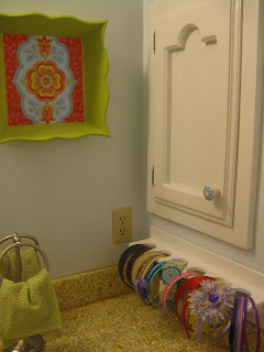 Craft organizer installed on bathroom wall, holding headbands