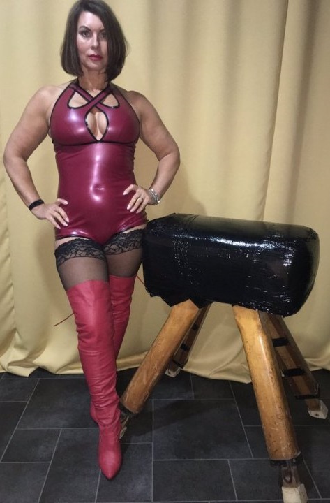 Mature dominatrix in black stockings and pink boots