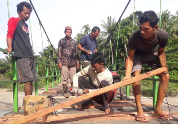 Kubu Anau Gotongroyong Perbaiki Lantai Jembatan Gantung