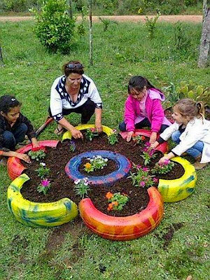 llantas cortadas a la mitad y unidas en forma de flor para plantas