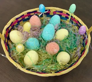 Colorful DIY Easter egg bath bombs in a basket.