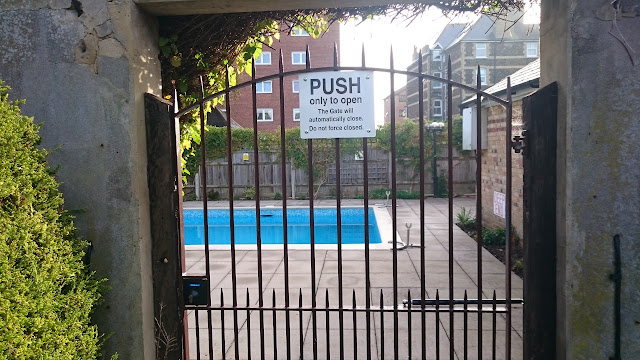 Push only to open sign on a hydraulic gate, dibond aluminium plastic aluminium composite sign with a swimming pool behind in the Ivy Side Wesgate.