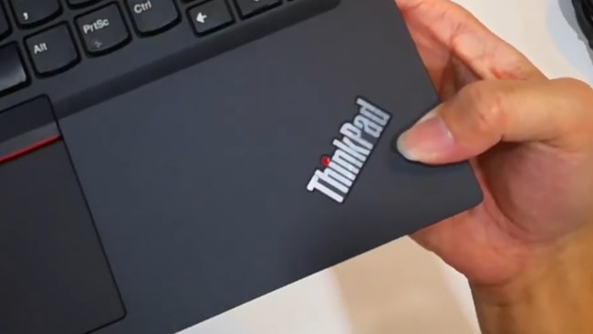 Fingerprints on the smooth matte black surface of Lenovo ThinkPad E14 laptop.