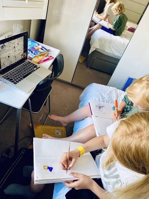 pictures of my daughters drawing a comic with an open laptop in front of them with a zoom session open  showing a newly drawn comic by Neill Cameron