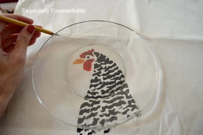 Tracing  a glass plate with pencil over chicken stencil