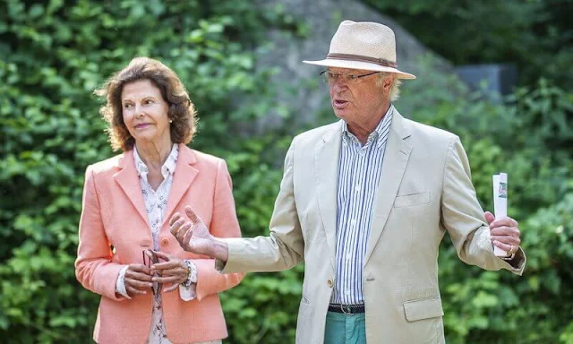 Queen Silvia wore pink blazer and white trousers. Silvia wore a floral print silk blouse