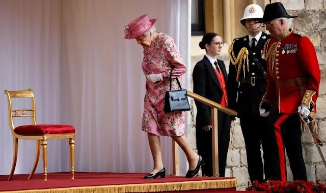 Queen Elizabeth wore a floral print dress by Stewart Parvin. First Lady wore a blue suit. The diamond Jardine star brooch