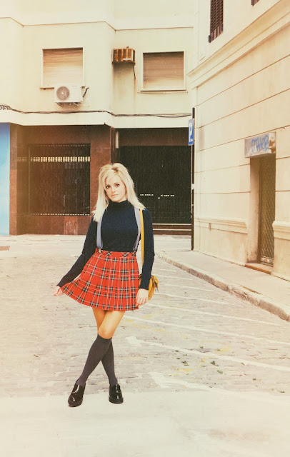 Alejandra Colomera vestida con jersey azul, falda roja cuadros escoceses, tirantes en color gris, calcetas gris y zapatos estilo colegial negro