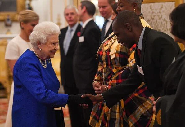 The Queen and Countess of Wessex hosted a reception. Queen wore royal blue dress. Emilia Wickstead skirt, Victoria Beckham top