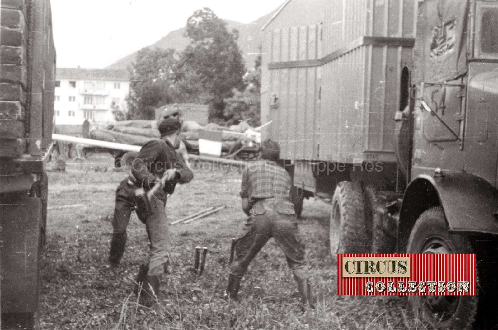 entre deux camions, les ouvriers du cirque plantent des pinces pour amarrer le chapiteau du cirque