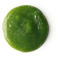 A bright green circle of shampoo with dark green circular bits on a bright background 