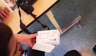 Visita do Farol Museu de Santa Marta Uma caixa pequena da maqueta com miniaturas de uma cama, mesa, fogão que simulam a casa de um faroleiro