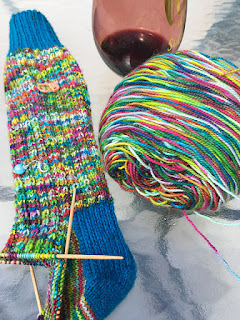 hand knit socks of rainbow variegated yarn and blue cuffs and heels