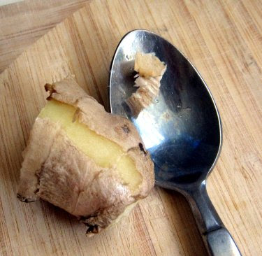 peeling fresh ginger with a spoon