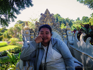 Woman Traveler Sitting In A Carved Seat In The Beautiful Garden Park In The Morning At The Village Tangguwisia North Bali Indonesia