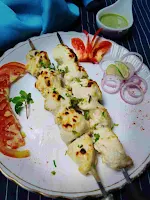 Serving Chicken malai tikka in a garnished plate with green chutney