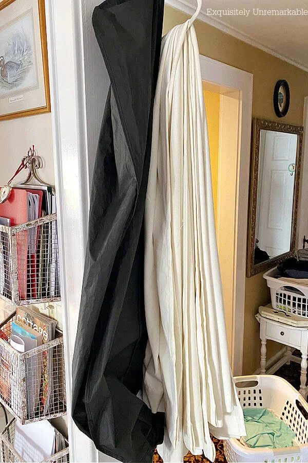 Curtain panels folded and hung on hanger next to garment bag