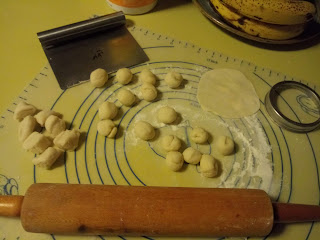 balls of dough divided with bench scraper and rolling pin on silicon mat