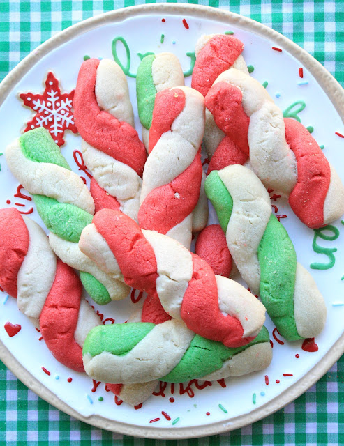 twisted red and green peppermint stick cookies piled on a holiday cookie tray